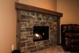 Stone wall wood fireplace with mantle